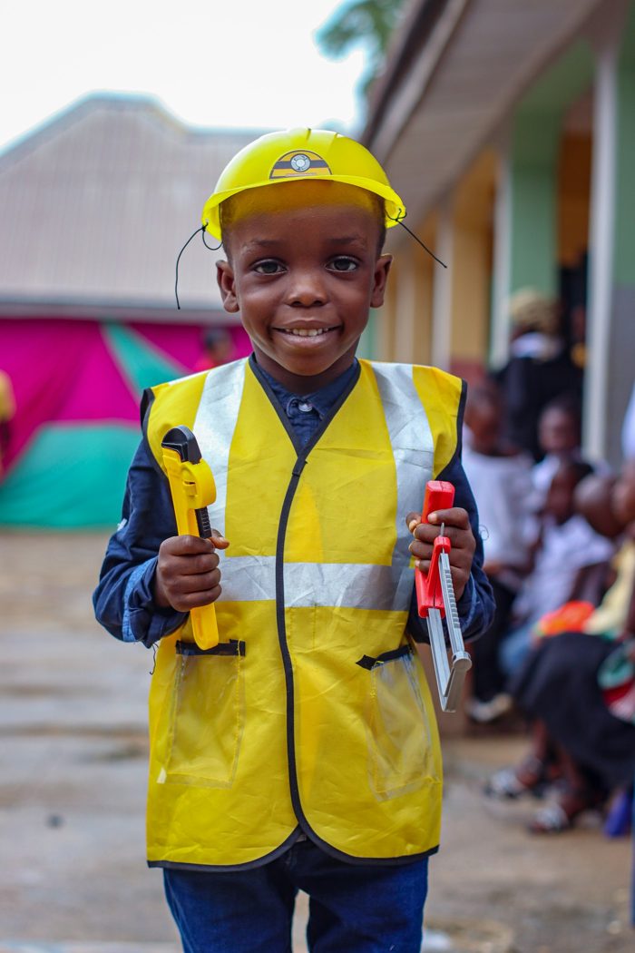 A boy in a hard hat holding tools