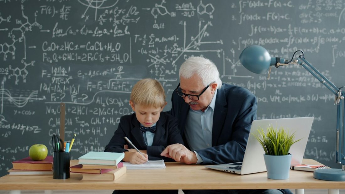A boy and his mentor at a desk